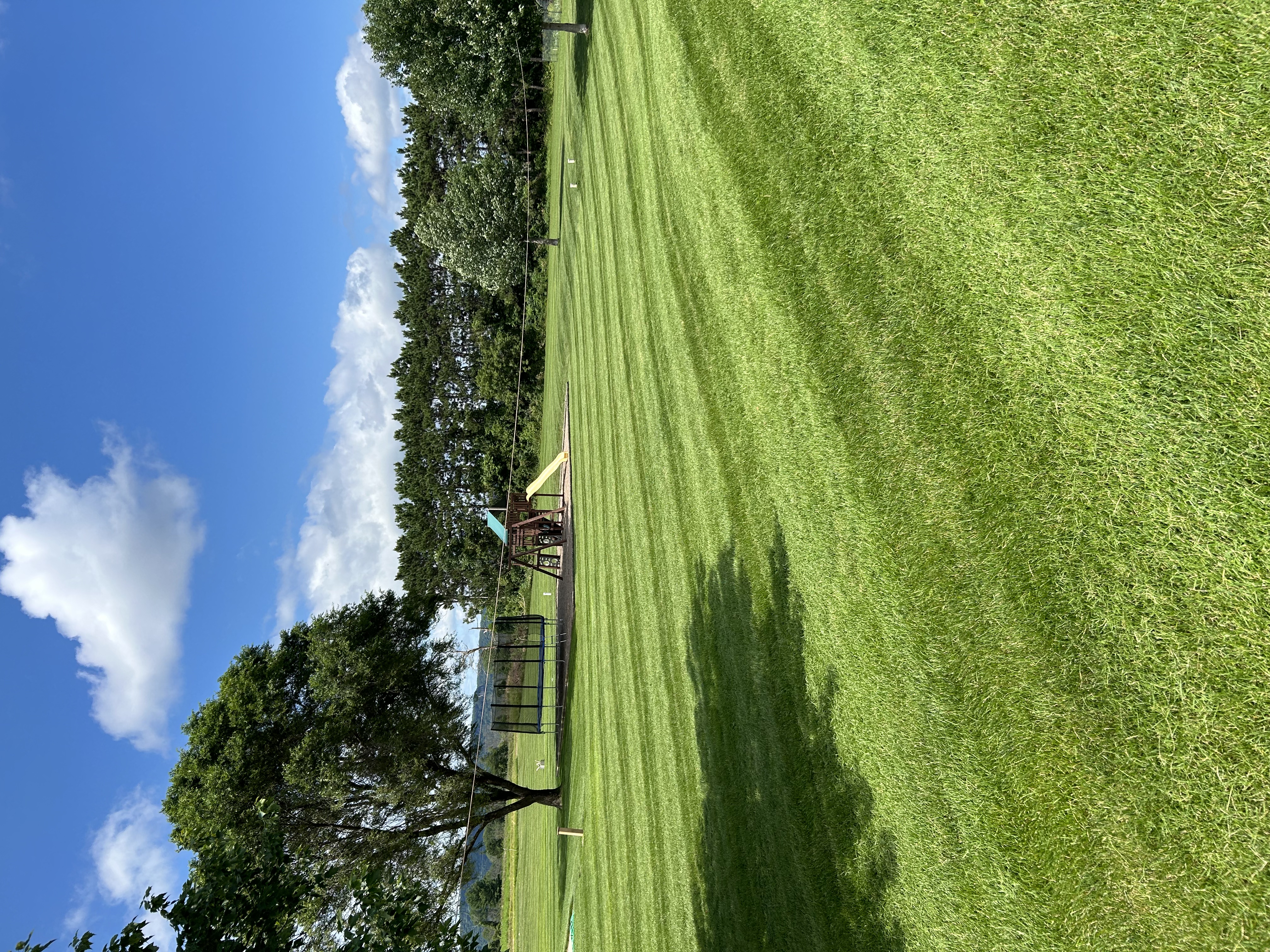 Large open lawn mowed with blue sky
